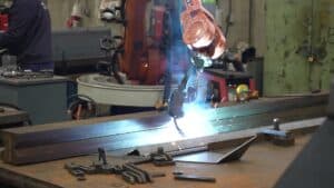 Robotic welding arm working on a metal assembly
